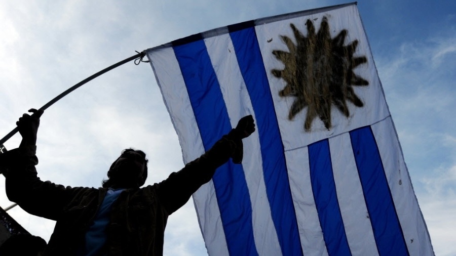 Torcedor do Uruguai tremula bandeira de seu país antes do jogo contra o Paraguai - AFP PHOTO / Maxi Failla