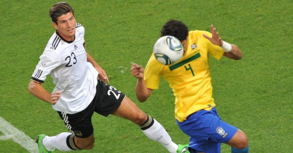 Zagueiro Thiago Silva afasta a bola enquanto é pressionado por Mario Gomez, atacante alemão