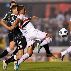 O são-paulino Lucas escapa de dois corintianos antes de tentar um chute durante o clássico no Morumbi - Júnior Lago/UOL