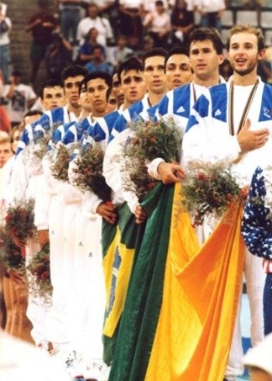 Com Tande à frente, a seleção masculina de vôlei canta o Hino Nacional no pódio, depois de conquistar o ouro olímpico