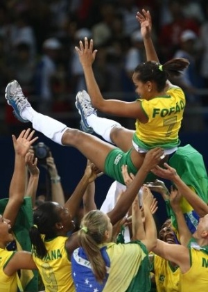 A levantadora Fofão, capitã da seleção de vôlei campeã olímpica, é jogada para o alto pelas companheiras na China