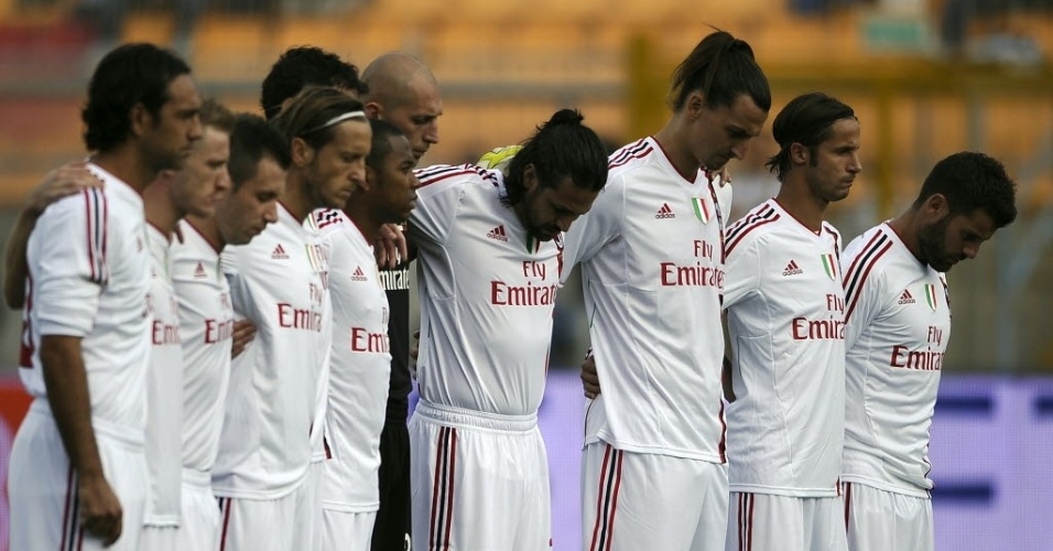 Jogadores do Milan se reúnem para respeitar um minuto de silêncio dedicado ao piloto morto Marco Simoncelli 