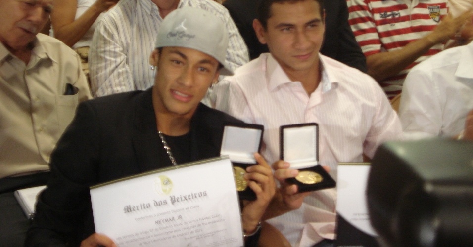 Neymar e Paulo Henrique Ganso exibem a Medalha do Mérito Peixeiro, condecoração dada pelo Santos aos campeões da Libertadores (07/11/11)