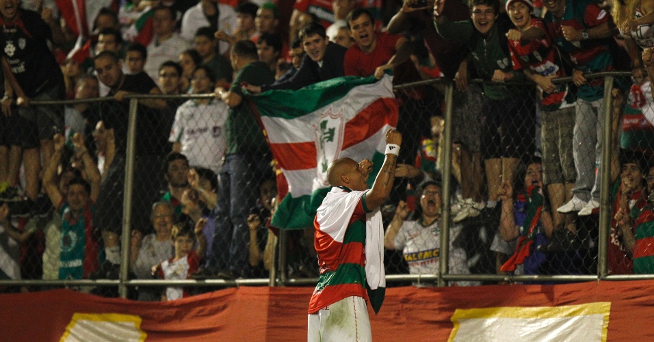 Edno carrega bandeira da Portuguesa e comemora título da Série B perto dos torcedores no Canindé