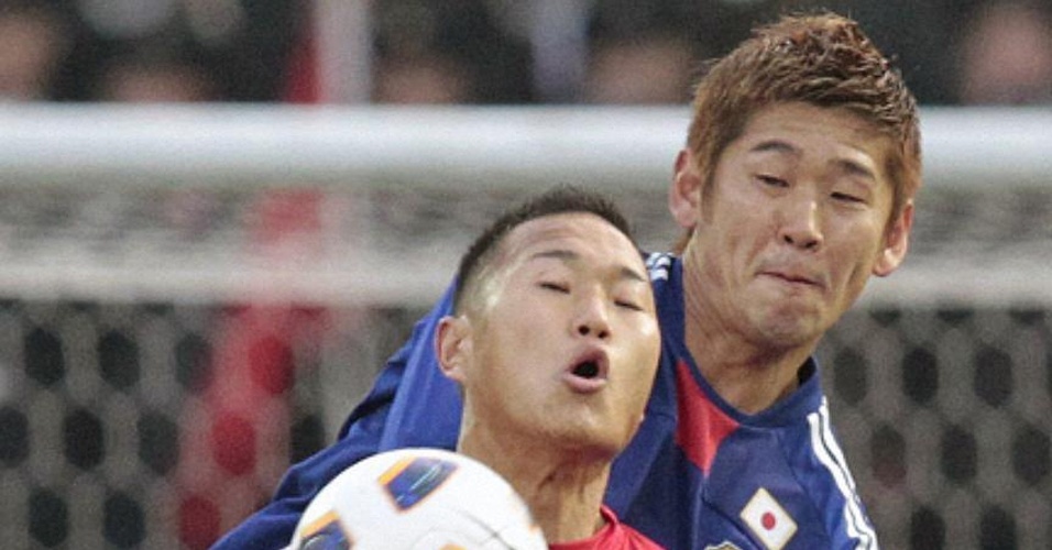 Atacante camisa 9 da Coreia do Norte Jong Tae-se (e) disputa a bola com o japonês Yuzo Kurihara na vitória dos coreanos por 1 a 0 nesta terça-feira