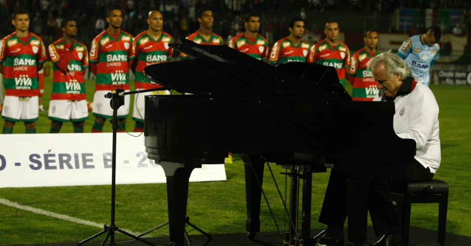 O maestro João Carlos Martins toca o hino nacional no piano antes do confronto entre Portuguesa e Duque de Caxias, pela Série B