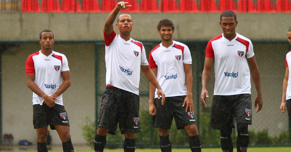 Mesmo sob chuva, Lucas (e), Luis Fabiano e os outros jogadores do São Paulo treinaram forte no CT de Cotia