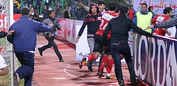 Jogadores do Al Ahly correm do gramado em meio à confusão - AFP PHOTO/STR