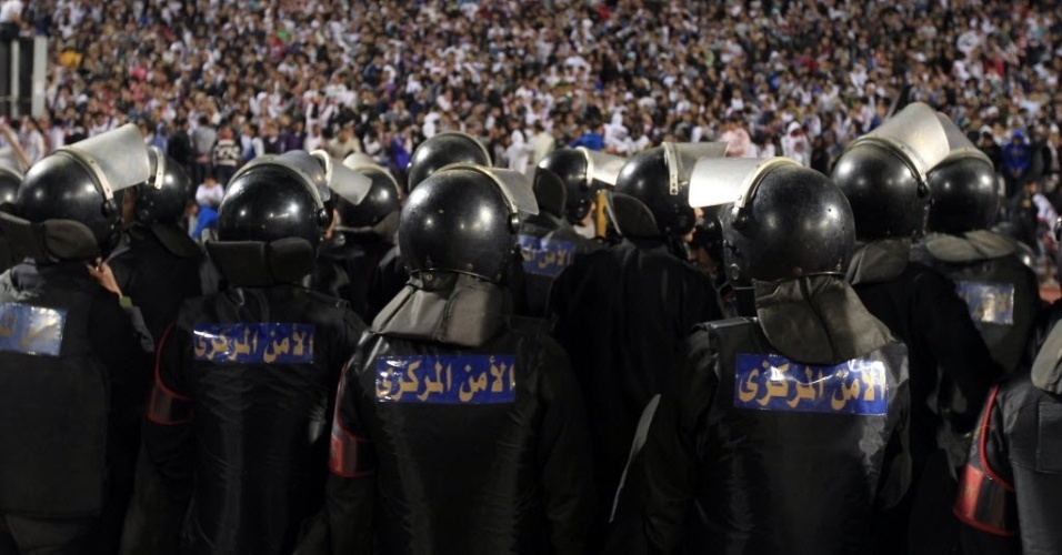 Policiais fazem barreira contra a torcida após confusão em partida de futebol no Egito