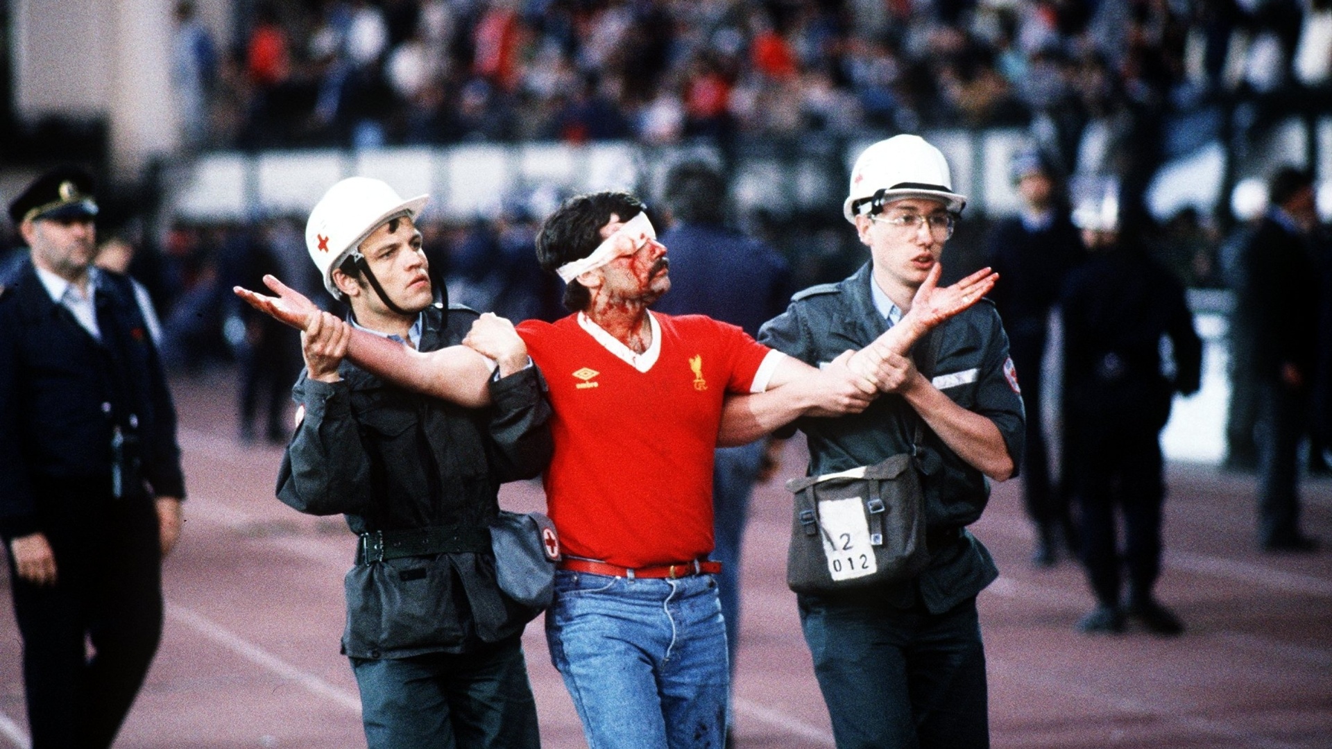 Torcedor do Liverpool é levado por policiais após agredir torcedores da Juventus no estádio de Heysel, na Bélgica, na final da Liga dos Campeões em 1985 - David Cannon/AllSport