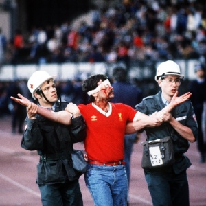 Torcedor do Liverpool é levado por policiais após agredir torcedores da Juventus no estádio belga - David Cannon/AllSport