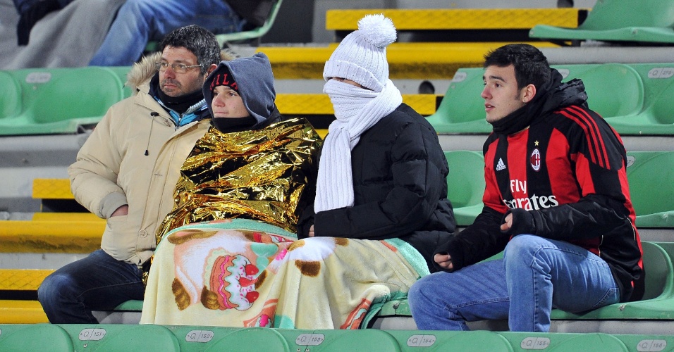 Torcedores do Milan se protegem do frio para assistir jogo contra a Udinese, pelo Campeonato Italiano