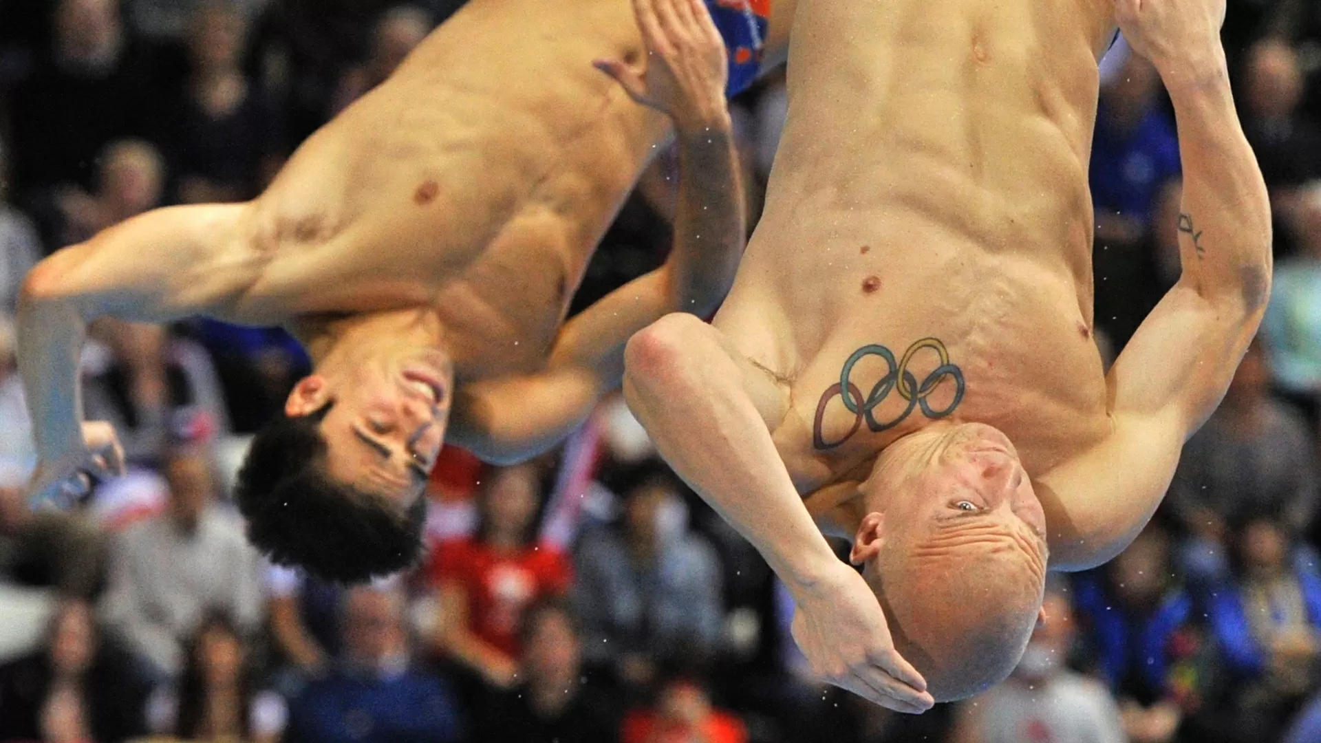 Os britânicos Christopher Mears (esq) e Nicholas Robinson Baker saltam do trampolim de 3 m em Londres - Toby Melville/Reuters