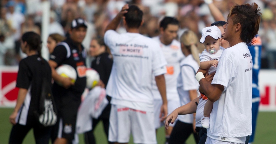 Neymar entra com o filho Davi Lucca em campo antes do clássico contra o Corinthians, na Vila Belmiro