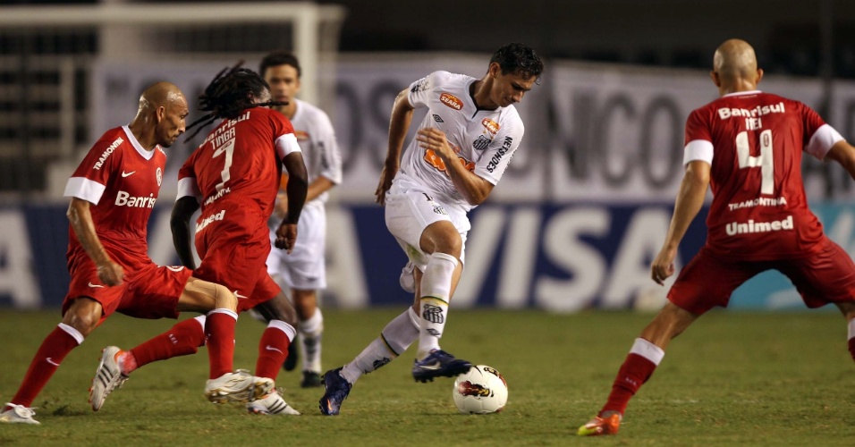 Cercado por jogadores do Internacional, Ganso tenta a jogada durante a vitória do Santos