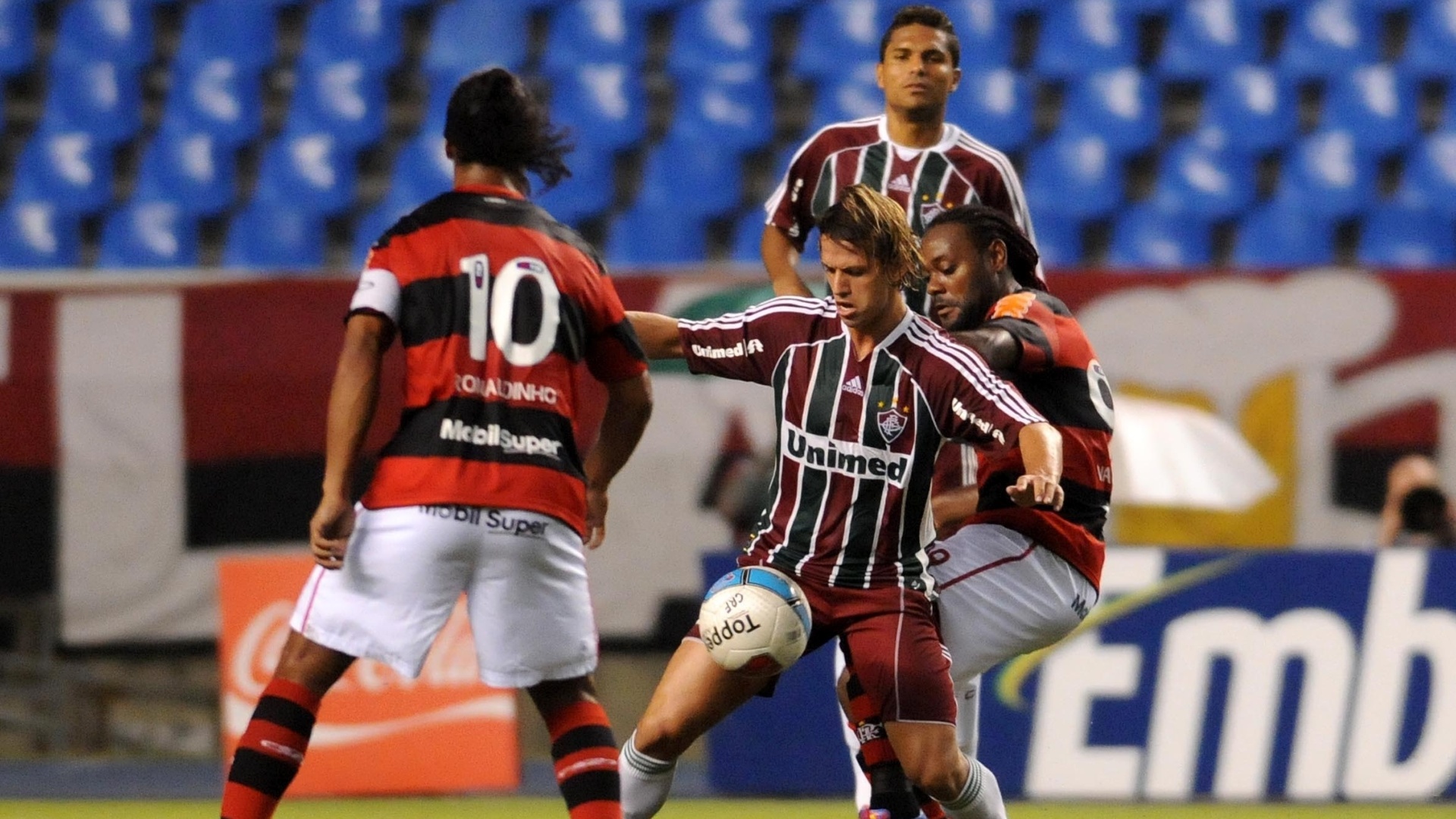 Ronaldinho e Vágner Love disputam a bola com Diguinho (c), do Fluminense