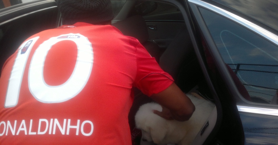 Ronaldinho acomodou o cachorro no banco de trás de seu carro antes de deixar a Gávea