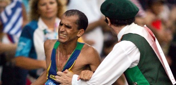 Cornelius Horan agarra o maratonista Vanderlei Cordeiro de Lima, que liderava a maratona em 2004
