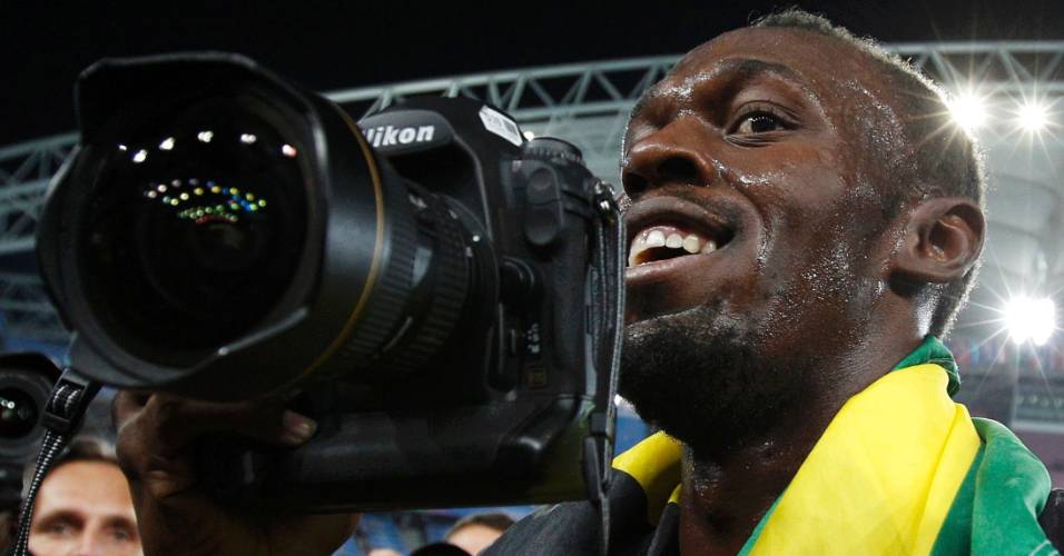 Usain Bolt pega câmera e vira fotógrafo depois de vencer os 200 m rasos no Mundial de atletismo em Daegu (03/09/2011)