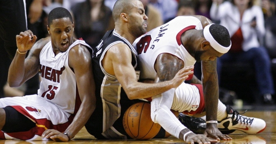 LeBron James (d), Tony Parker (c) e Mario Chalmers se enroscam no chão durante partida entre Heat e Spurs pela NBA (18/01/2012)