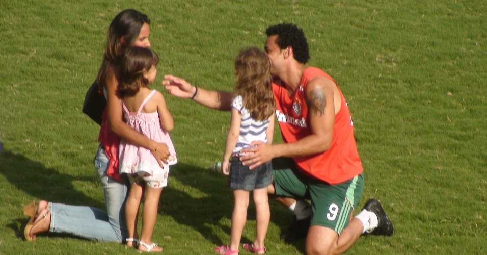 Fred, com sua filha, brinca com uma torcedora do Fluminense e outra criança