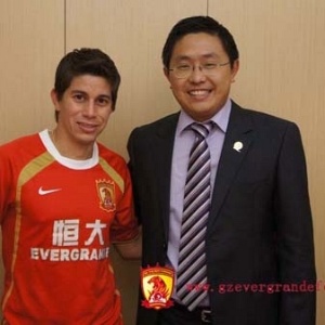 O meia Conca posa com a camisa do Guangzhou  ao lado do presidente do clube Liu Yongzhuo - Divulgação