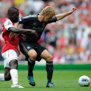 Emmanuel Frimpong (esq.) disputa bola com Kuyt; ganês foi expulso e prejudicou o Arsenal   - Tom Hevezi/ AP Photo