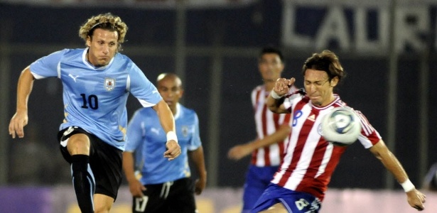 Diego Forlán e Edgar Barreto disputam a bola em duelo entre Uruguai e Paraguai - EFE/Diego BenÌtez