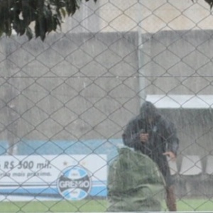 Profissional do Grêmio recolhe material de treino com forte chuva em Porto Alegre nesta quarta-feira - Marinho Saldanha/UOL Esporte