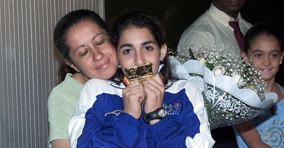 Abraçada à mãe Geni, Daniele Hypolito exibe a medalha de ouro conquistada por ela na etapa de Cottbus da Copa do Mundo de 2002