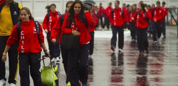 Atletas da delegação do Chile tentam se proteger da chuva que atinge Guadalajara
