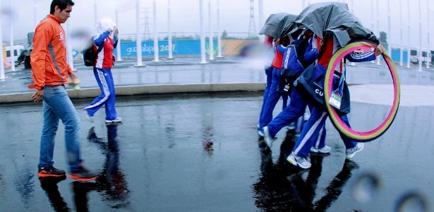 Atletas cubanos se protegem da chuva na Vila do Pan: treinos cancelados