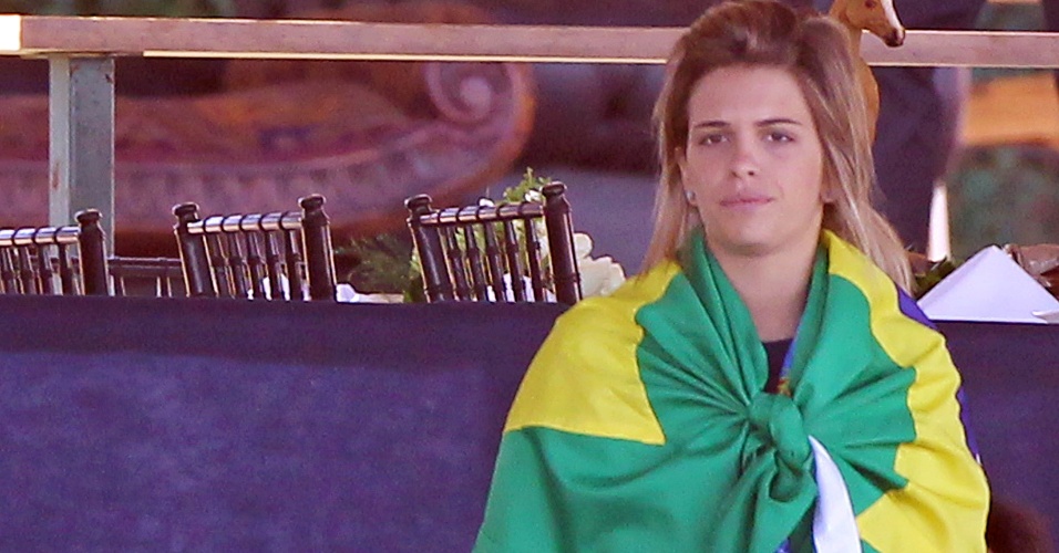 Amazona Luiza Almeida se enrola em bandeira brasileira antes de iniciar a prova de adestramento do hipismo (16/10/2011)