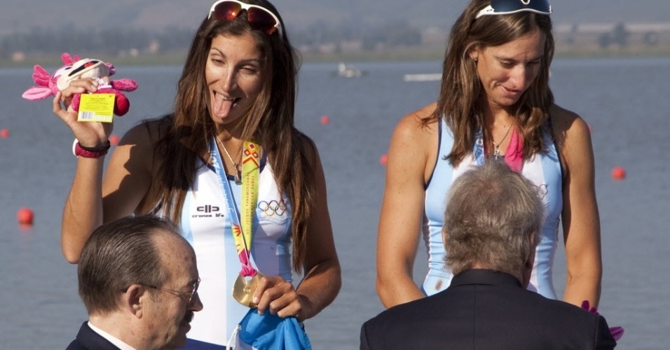 Argentina Maria Abalo mostra a língua ao receber medalha de ouro no remo ao lado da companheira Maria Best (17/10/2011)