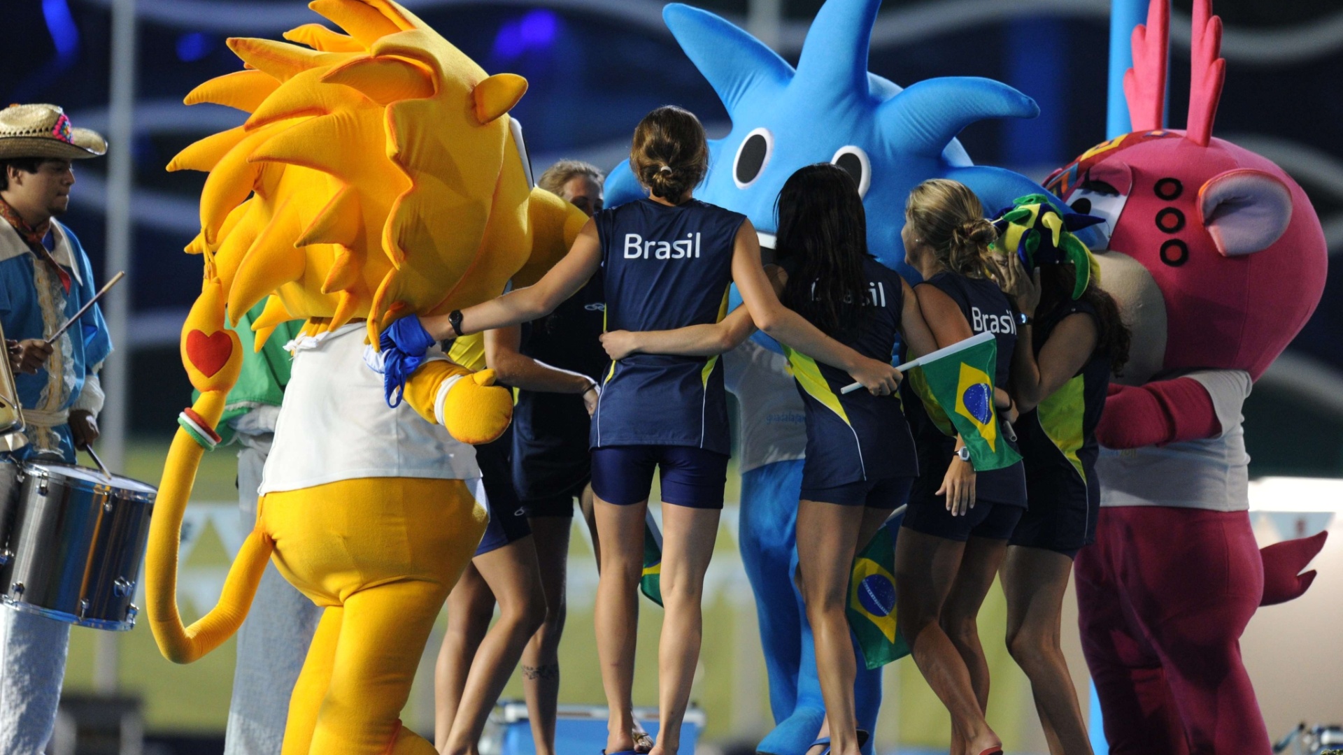 Meninas da equipe de nado sincronizado do brasil dançam com os mascotes do Pan de Guadalajara