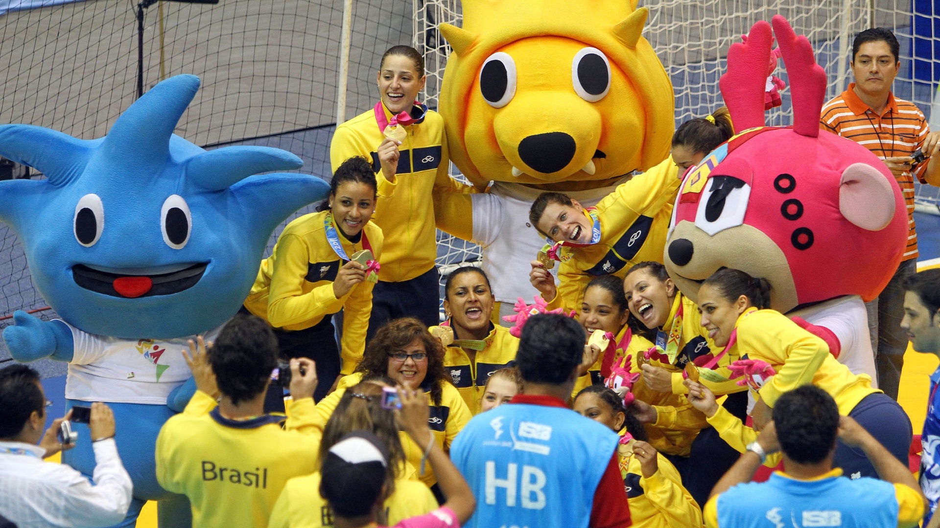 Jogadoras brasileiras comemoram com mascotes do Pan após a conquista do ouro no handebol (23/10/2011)