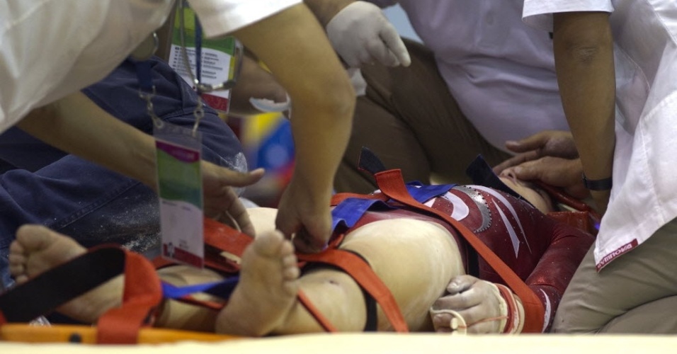 Peruana Sandra Collantes recebe atendimento médico após bater a cabeça na trave durante finais do individual geral da ginástica