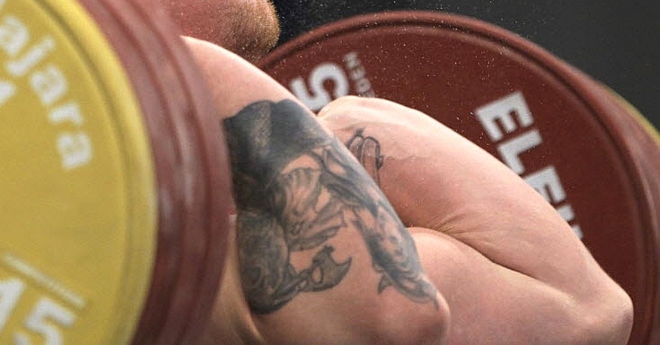 Donald Shankle, dos EUA, expões suas tatuagens enquanto tenta erguer os pesos em prova do Pan (27/10/2011)