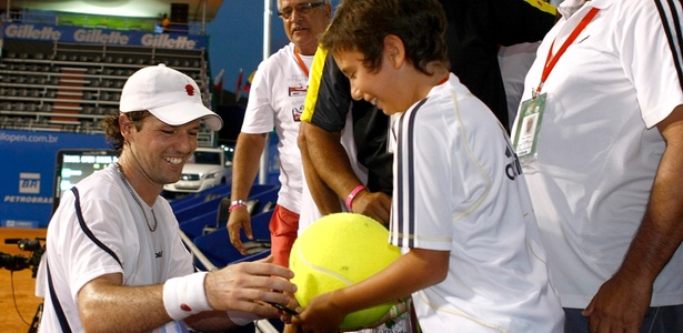 Ricardo Mello autografa grande bola de tênis para garoto na Costa do Sauipe (BA) - Divulgação