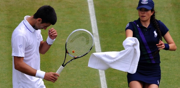 Novak Djokovic recebe toalha na partida contra o australiano Tomic em Wimbledon - Carl de Souza/AFP