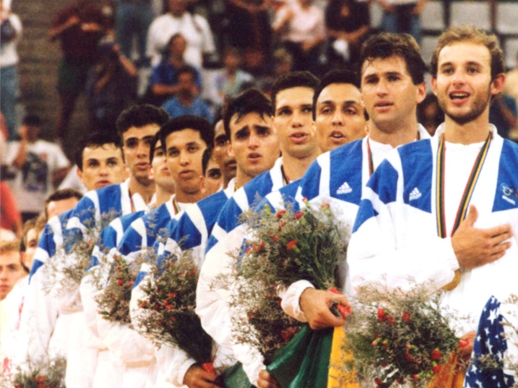 Jogadores da seleção brasileira de vôlei ouvem o Hino Nacional após a conquista do ouro olímpico em Barcelona-1992